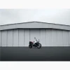 Tirage intitulé Flat Twin Hangar qui représente une BMW Nine T Urban GS devant un hangar d'avion.