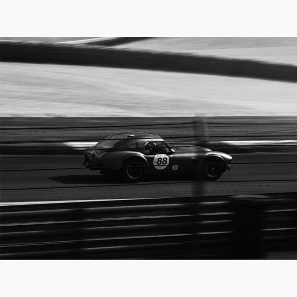 Tirage intitulé Tour de Chauffe qui représente une voiture de collection sur circuit en noir et blanc.